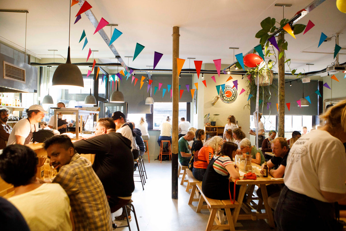 the restaurant full for a party, bunting up, the open kitchen behind